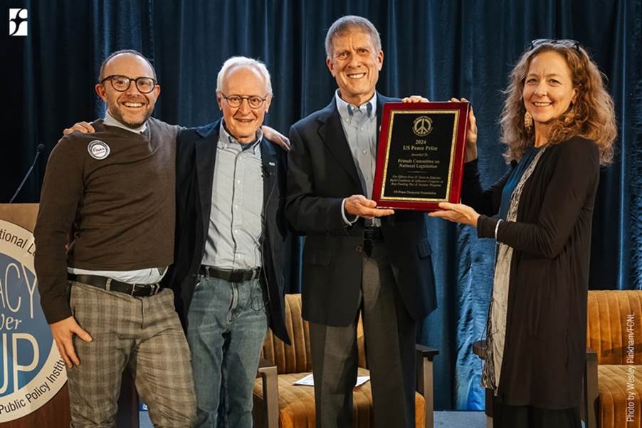 A group of people holding a plaque
Description automatically generated